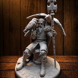 May include: A detailed gray sculpture of a seated figure with a long beard, holding a spear and flanked by two birds. The figure is wearing boots and a cloak, and is seated on a round base with engraved symbols. The background is a wooden surface.