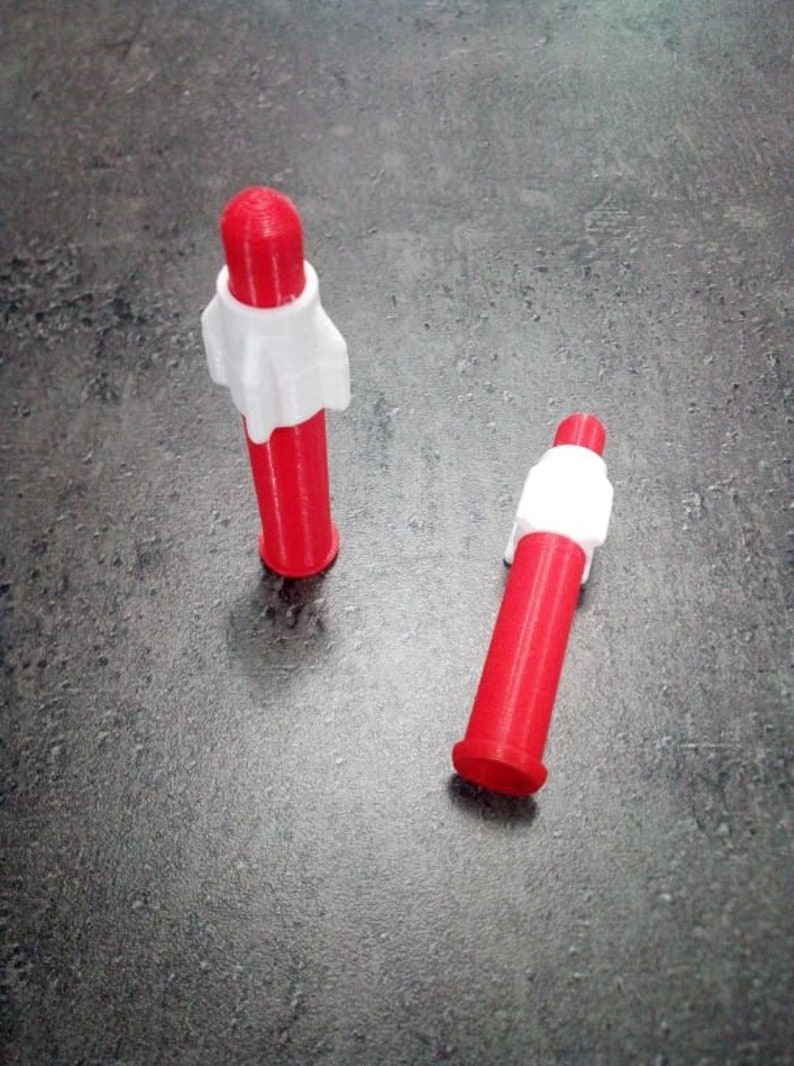 Puede incluir: Dos tapas de pl&aacute;stico rojo y blanco con la parte superior redondeada y un anillo blanco alrededor del medio.