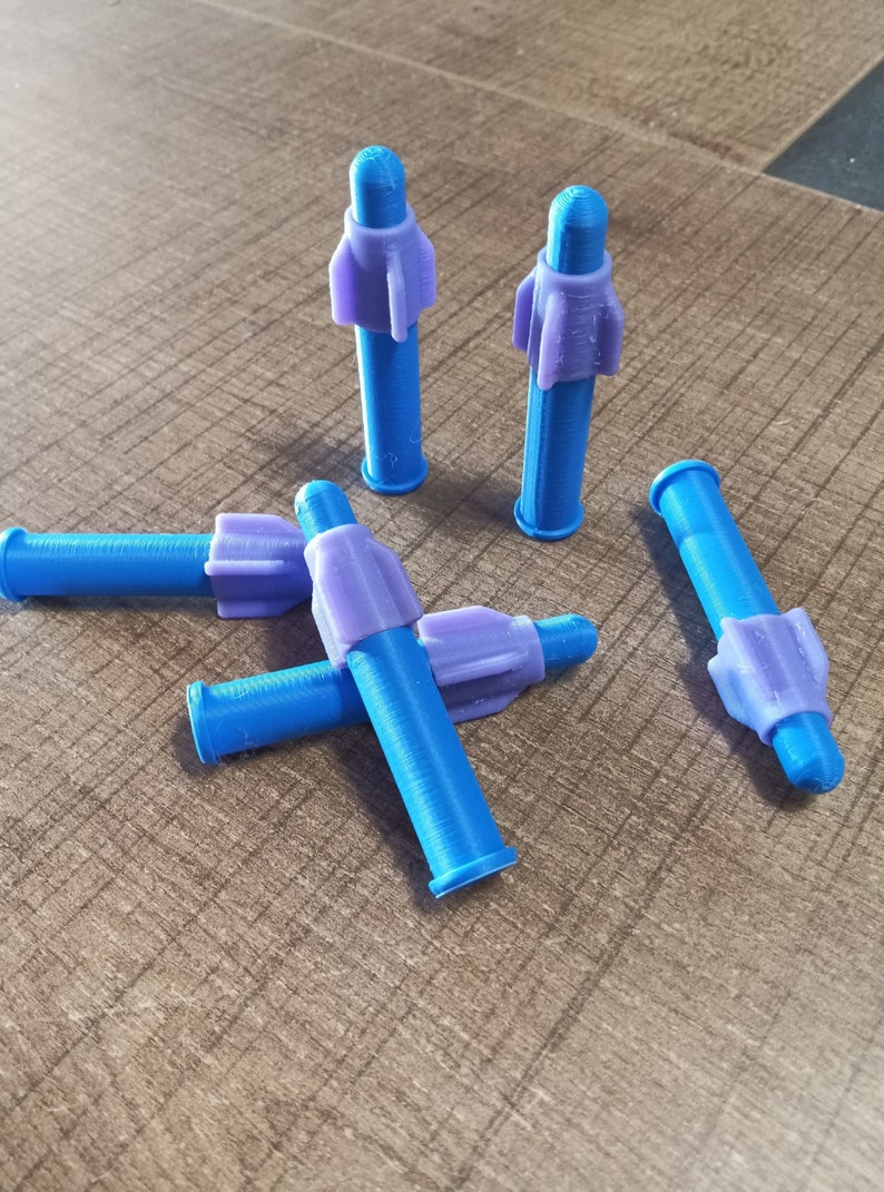 Puede incluir: Cinco objetos de pl&aacute;stico en forma de cohete, azules y morados. Los objetos est&aacute;n sobre una superficie de madera.