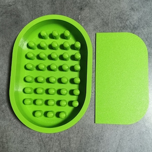 May include: A bright green plastic dog dish with a raised grid pattern and a matching flat rectangular dish.