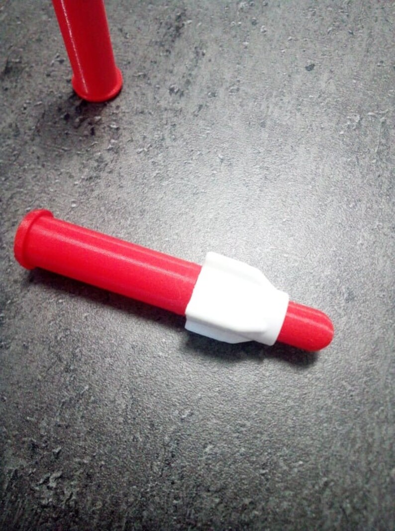 Puede incluir: Una boquilla de pl&aacute;stico roja y blanca para una pistola de pegamento. La boquilla mide aproximadamente 12,5 cm de largo y tiene una punta blanca.