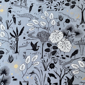 May include: Pale blue fabric featuring a swamp-themed pattern. The design showcases black and white illustrations of trees, birds, plants, and water elements. Gold accents are used for the sun and stars.
