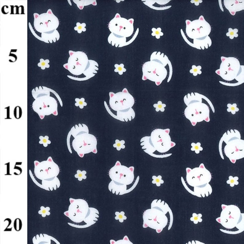 May include: Dark navy fabric patterned with white cartoon cats and small yellow flowers. The cats are in various poses, some upright and others upside down. The fabric is suitable for sewing projects.