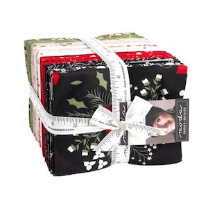 May include: A bundle of fabric squares in shades of black, red, and green, secured with a white ribbon. The fabric displays floral and leaf designs. A tag with a woman's image is attached to the ribbon.