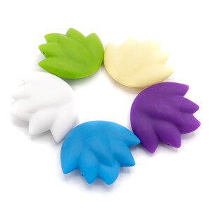 May include: Five silicone lotus flower shaped beads in different colors: green, white, yellow, purple, and blue.