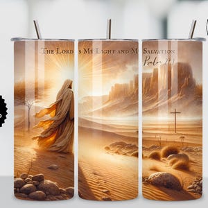 May include: A stainless steel tumbler with a desert landscape design featuring a figure in flowing robes, a cross, and the text "The Lord is My Light and My Salvation, Psalm 27:1." The tumbler has a straw and a lid.