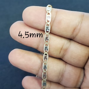 May include: A gold chain necklace with a 4.5mm width. The chain is made of two-tone gold, with alternating links of yellow and white gold.