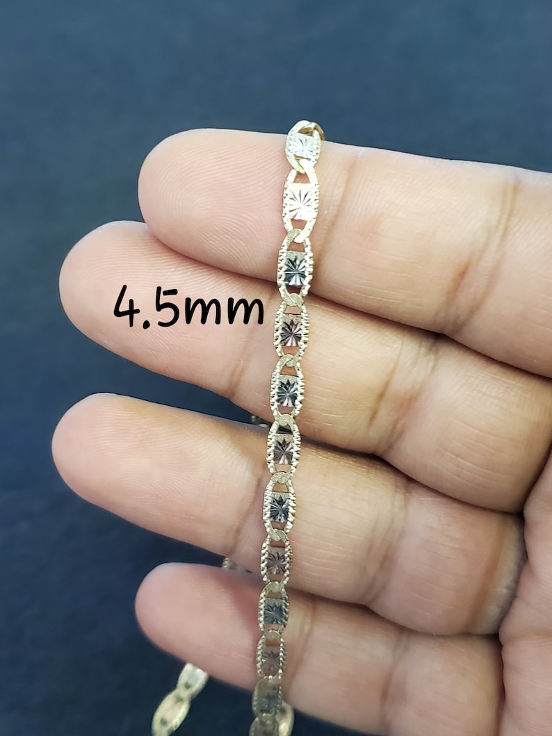 May include: A gold chain necklace with a 4.5mm width. The chain is made of two-tone gold, with alternating links of yellow and white gold.