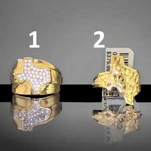 May include: Two gold rings shaped like the state of Texas. The first ring is set with clear cubic zirconia stones. The second ring has a textured surface. The price tag reads $375.00.
