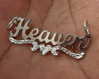 May include: Silver pendant necklace with the name "Heaven" spelled out in cursive lettering with a small heart charm in the center.