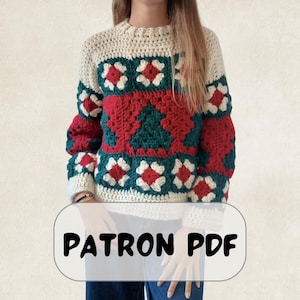 Puede incluir: Un suéter de ganchillo de manga larga con un patrón de cuadrados granny en crema, rojo y verde oscuro. El diseño incluye un motivo central de árbol de Navidad en verde oscuro rodeado de cuadrados rojos y crema. El texto PATRON PDF es visible.