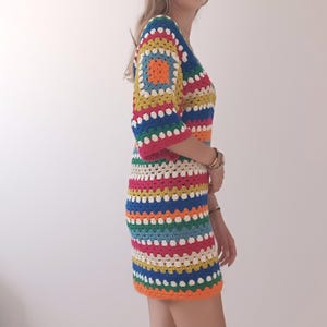 May include: A colorful crochet dress with a striped pattern in shades of blue, green, yellow, orange, pink, and white.
