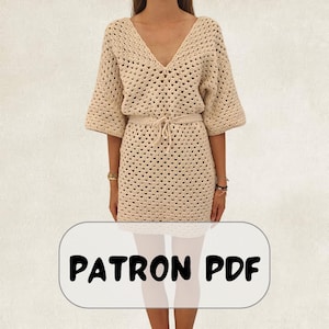 May include: A beige crochet dress featuring a V-neckline, elbow-length sleeves, and a matching tie-waist belt. The garment is crafted with an open-work granny square stitch pattern. A rectangular label at the bottom displays the text PATRON PDF.