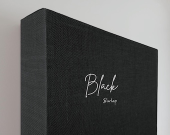 May include: A close-up of a black burlap canvas. The word "Black" is written in a cursive font, with "Burlap" written below it. The canvas is mounted on a wooden frame.