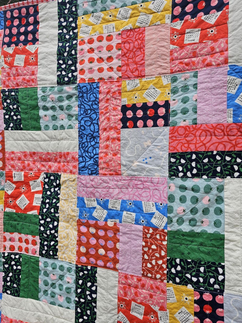 May include: A patchwork quilt with a variety of colorful fabrics, including red, pink, blue, green, yellow, and white. The quilt is made up of squares and rectangles, and the fabrics are sewn together in a random pattern. The quilt is made of cotton fabric and has a soft, comfortable feel.