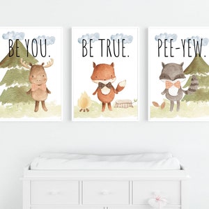 May include: Three framed watercolor prints featuring woodland animals. The prints include a moose, fox, and raccoon, each wearing a bow tie. Text above each animal reads "BE YOU.", "BE TRUE.", and "PEE-YEW."