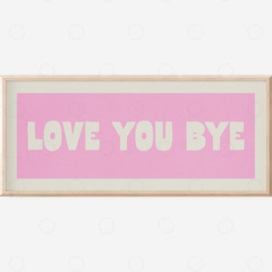 以下が含まれることがあります： 白いサンセリフフォントで「LOVE YOU BYE」というテキストが書かれた、ピンクと白の額装されたプリントです。