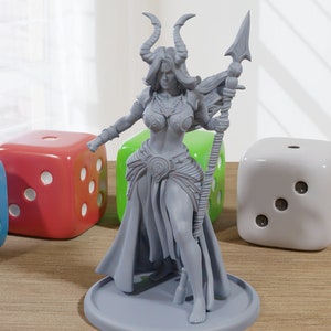 May include: A grey 3D printed miniature of a female figure with horns, holding a spear. She is wearing a skirt and a necklace. The miniature is standing on a round base.