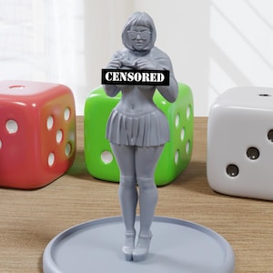 May include: A gray figurine of a person wearing a skirt and glasses, holding a camera in front of their chest. The figurine is standing on a gray circular base. The word "CENSORED" is printed on a black bar in front of the figurine.