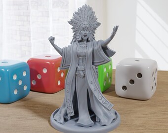 May include: A gray 3D printed miniature figurine of a woman wearing a headdress with feathers and a long robe. The figurine is standing on a round base and is posed with her arms raised.
