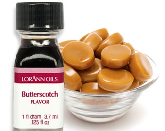 May include: A small glass bottle of LorAnn Oils Butterscotch Flavor with a black cap, and a label with red and white text. Beside the bottle is a clear glass bowl filled with caramel candies.