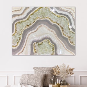 Peut inclure: Peinture abstraite avec un motif d'agate blanc, gris et or. La peinture présente un motif tourbillonnant de blanc et de gris avec des accents dorés. Le motif d'agate rappelle une pierre naturelle.