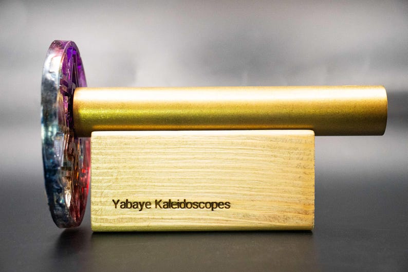 Detailed view of the vibrant colors and unique epoxy resin texture encasing the handmade brass kaleidoscope. Showcases the artistic depth and glossy finish of the body material.