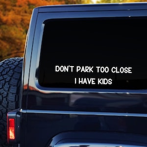 Peut inclure: Un SUV noir avec un autocollant blanc sur la vitre arrière qui indique "Ne vous garez pas trop près, j'ai des enfants".