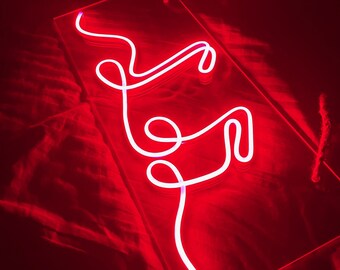 May include: A white neon sign in the shape of a cursive letter "F" on a red background.