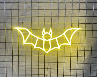 May include: A lemon yellow neon bat sign, 20x8 inches, against a gray grid background. The sign's outline depicts a bat with outstretched wings. The text at the bottom reads "Size 50x20 cm (20x8 inches) Lemon Yellow color."