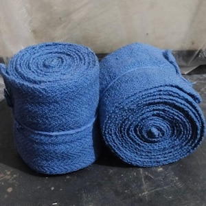 May include: Two rolls of blue medical bandage, one is rolled up and the other is unrolled.