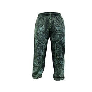 May include: Green sweatpants with a geometric pattern. The pattern is in shades of green and white and features a variety of shapes and symbols.