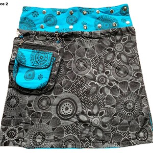 May include: A black and white floral print skirt with a turquoise blue waistband and a matching turquoise blue pocket. The waistband has silver studs.