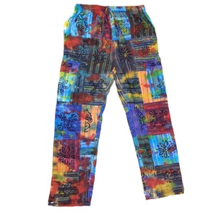 以下が含まれることがあります： 様々な花柄のパッチワークデザインが施されたマルチカラーのパンツ。パンツはドローストリングウエストバンドとゆったりとしたフィット感です。