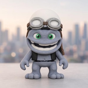 May include: A gray, cartoon-style character figurine featuring a wide, toothy grin and bright green eyes. The figure wears a white helmet with brown aviator-style goggles, a black vest, and has a stout, bipedal body with textured, rounded feet.