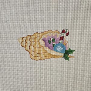 May include: Needlepoint design of a seashell filled with Christmas ornaments. The shell is tan and the interior is lavender. Ornaments include a red and white candy cane, a blue snowflake ornament, and green holly.