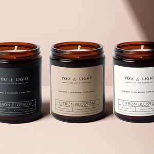 May include: Three amber glass candle jars with brown paper labels. The labels have the text "YOU & LIGHT" and "CITRON BLOSSOM".