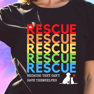 May include: Black t-shirt with a rainbow design that says "RESCUE" five times. The text is in a retro font. Below the text is the phrase "Because they can't save themselves" and a silhouette of a dog and cat.