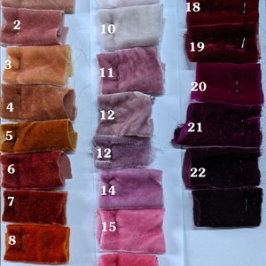May include: Swatch card displaying 23 fabric samples in a range of red, pink and orange hues. The samples are numbered 1 to 23.