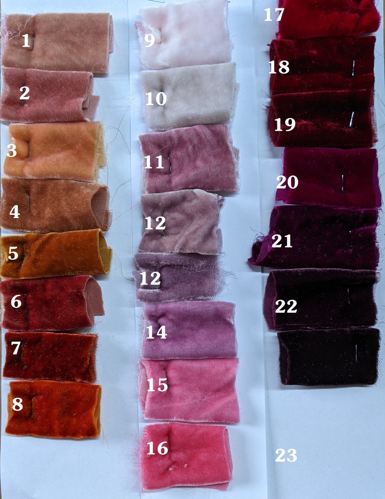 May include: Swatch card displaying 23 fabric samples in a range of red, pink and orange hues. The samples are numbered 1 to 23.