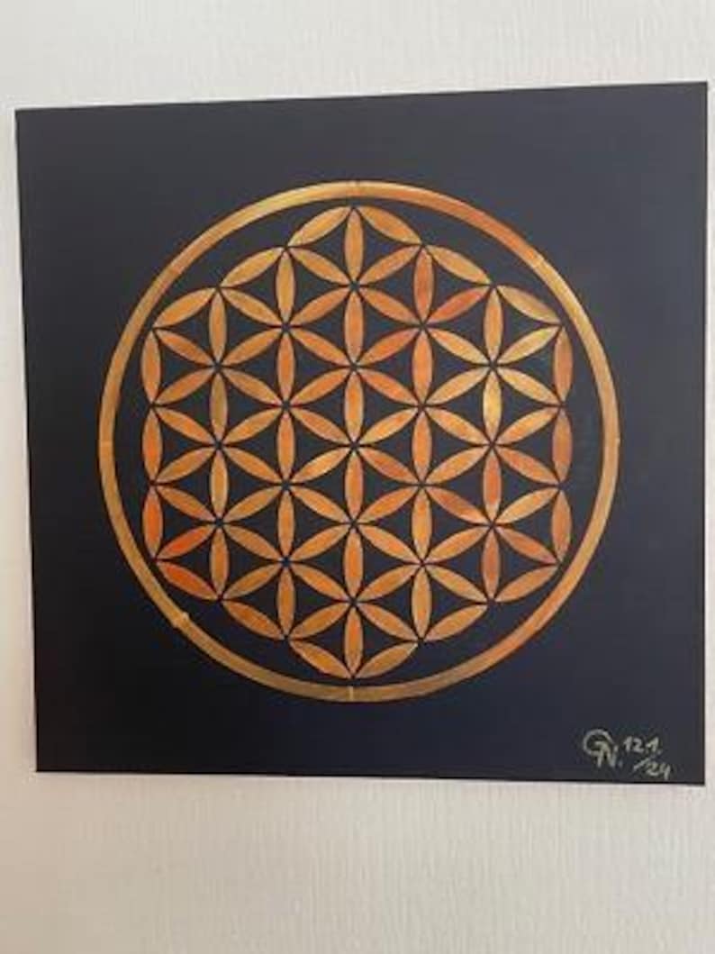 May include: A gold geometric pattern, known as the Flower of Life, is painted on a black canvas. The pattern is a repeating series of overlapping circles, creating a complex and intricate design.