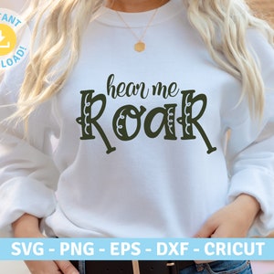 May include: White sweatshirt with the text "hear me roar" in black lettering with a decorative border.