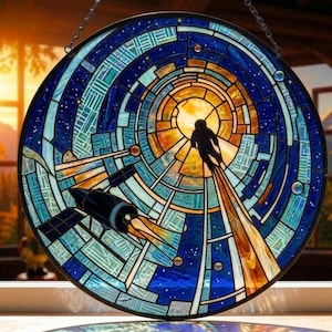 Könnte beinhalten: Rundes Buntglasfenster, das eine Weltraumszene darstellt. Das Design zeigt einen Astronauten als Silhouette, eine Rakete und eine stilisierte Darstellung des Weltraums mit blauen, orangefarbenen und weißen Glasteilen. Das Fenster hängt an einer Kette.