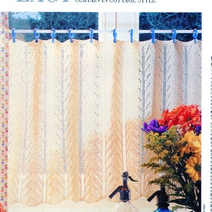 May include: A white crocheted curtain with a delicate pattern hangs in a window. The curtain is held up by blue clips. A rooster figurine sits on a counter below the window, and there are clear glass bottles and glasses on the counter.