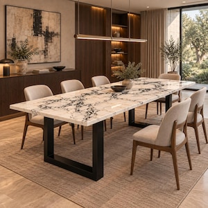 Peut inclure: Une table à manger rectangulaire avec un plateau en marbre blanc et noir et une base en métal noir en forme de U, entourée de six chaises rembourrées avec des pieds en bois. La surface de la table présente un motif veiné et une finition polie.