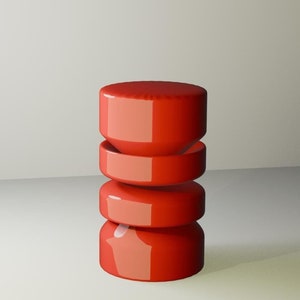 May include: A red, cylindrical, stacked display stand with a glossy finish. The stand is made of three separate pieces, each with a slightly different shape. The stand is sitting on a white surface.