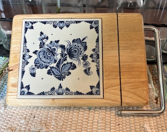 Tagliere per formaggio Delft Blue olandese con coltello integrato e base in legno chiaro, in ottime condizioni.