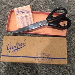 May include: A vintage pinking shears set in a brown box with the brand name "Griffon" and the text "Tru-Pink Pinking Shears Made in USA".