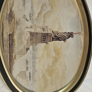 May include: Oval serving tray with a gold rim and black trim. The tray features a watercolour-style image of the Statue of Liberty and the New York City skyline. The tray is likely made of metal.