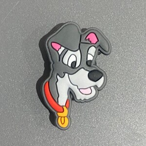 Könnte beinhalten: Ein grauer Cartoon-Hund mit einem roten Halsband und einem goldenen Anhänger. Der Hund hat weißes Fell im Gesicht und rosa Ohren.